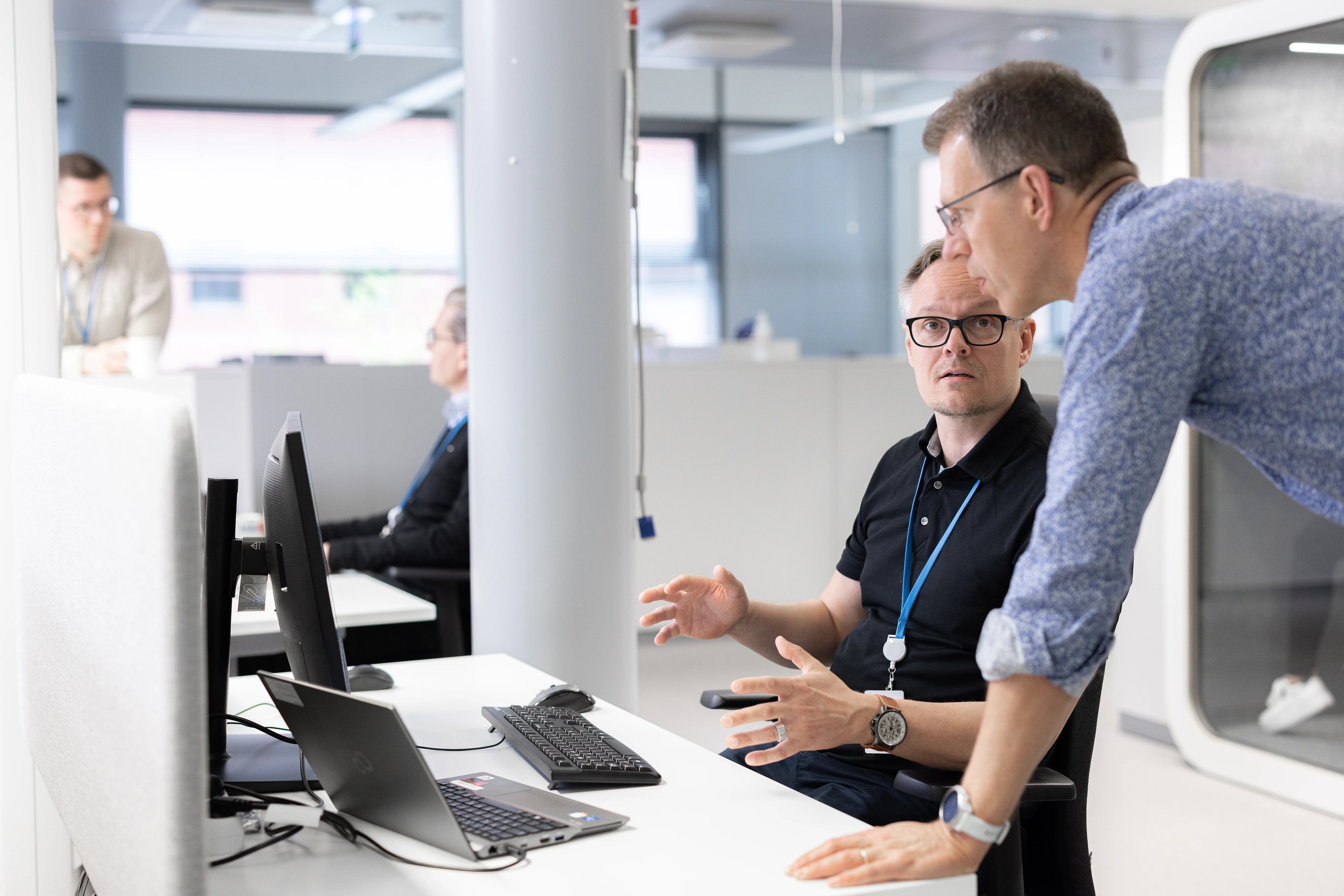 Colleagues in the office discussing something in front of a computer