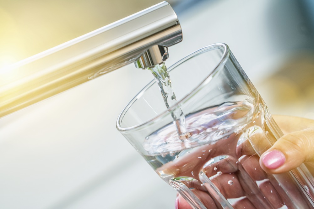 Tapping a glass of water in the kitchen