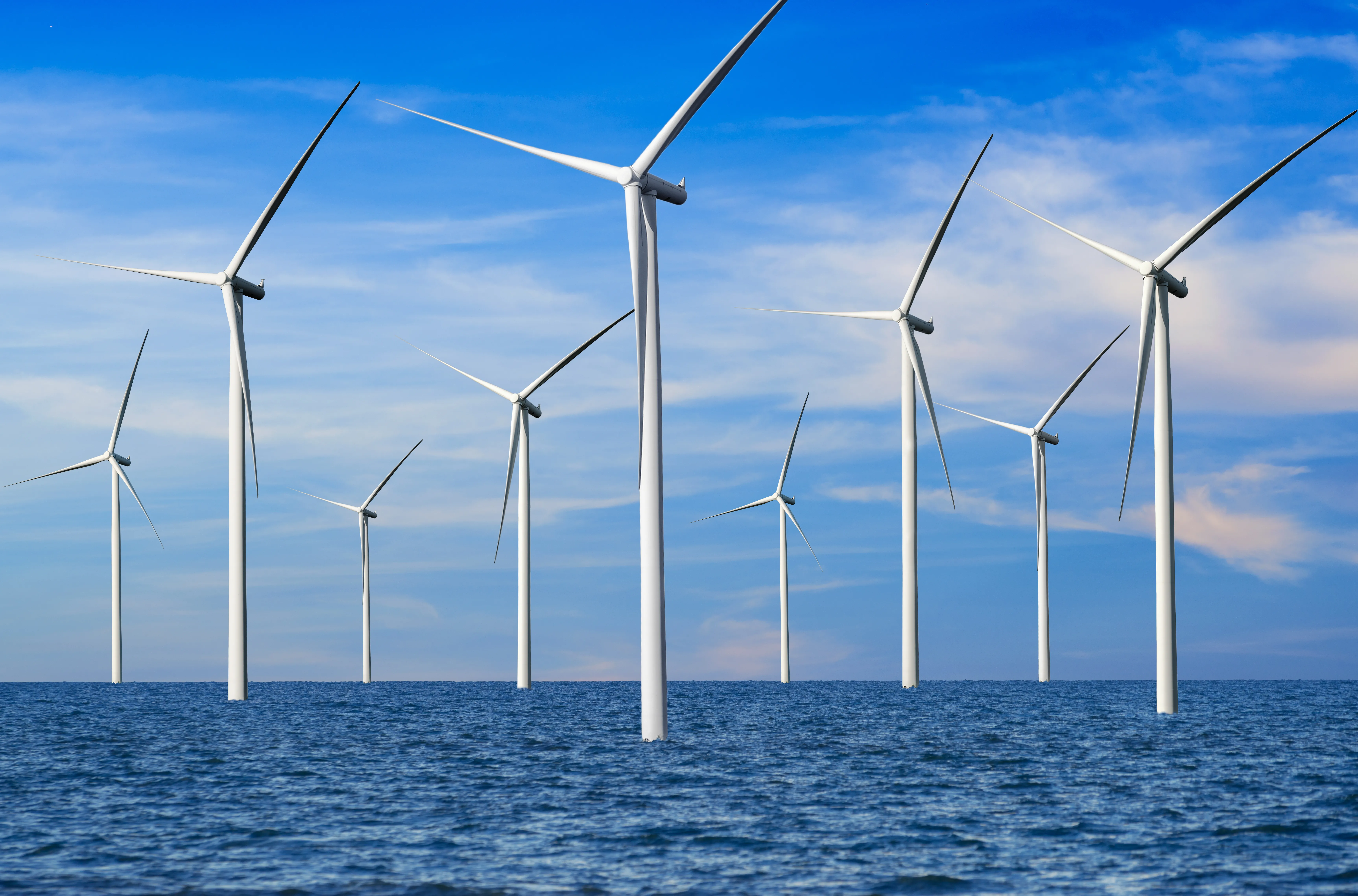 Offshore Kiwa inspected wind turbines in a calm ocean under a blue sky