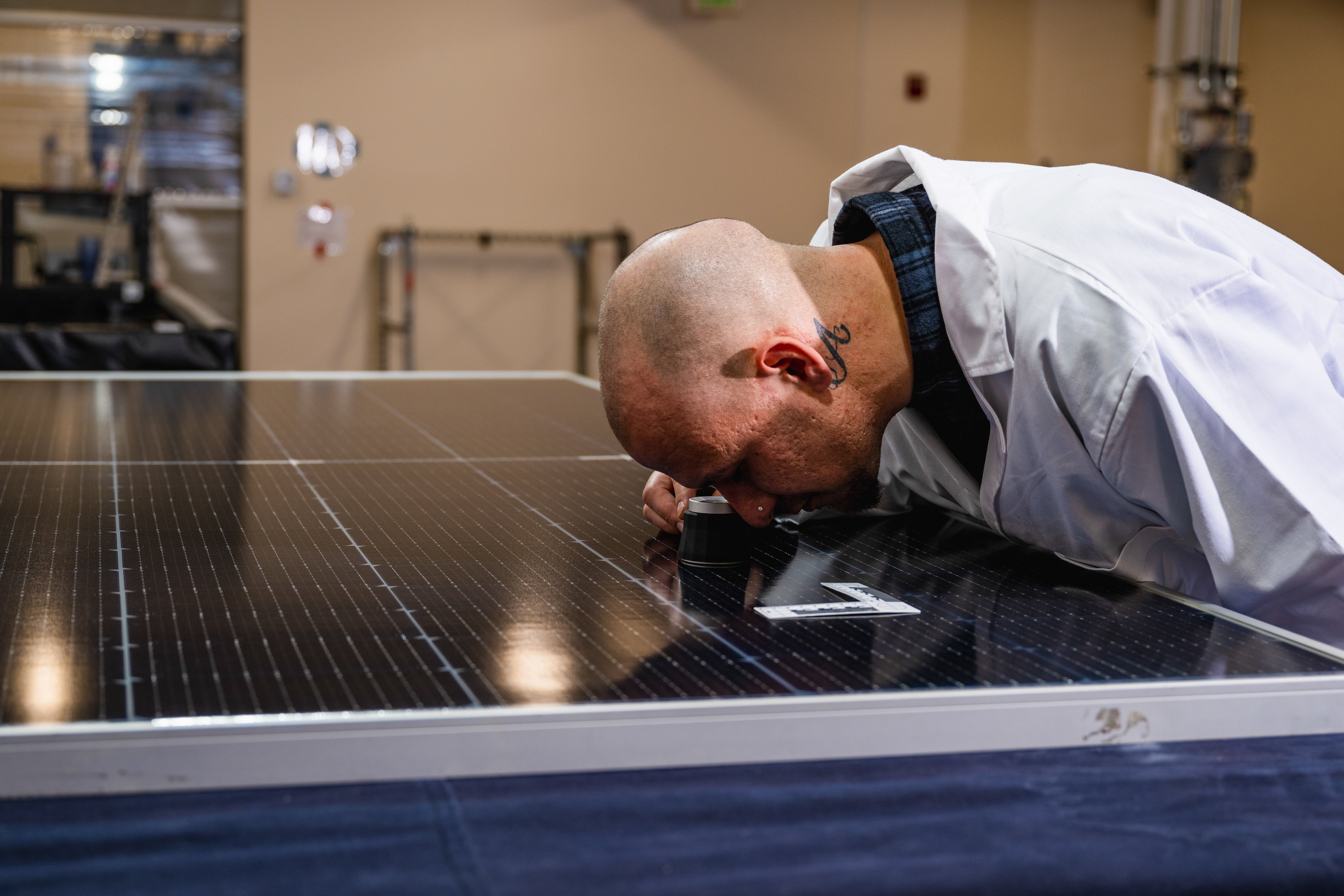 kiwa employee conducting a close-up  indoor module investigation on an solar panel